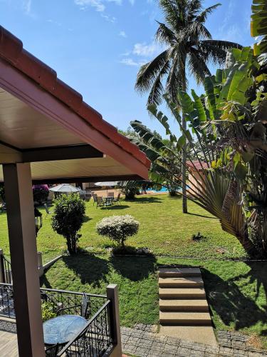 a view of a lawn with a palm tree and stairs at Sleep Soundly By The Sea in Trat