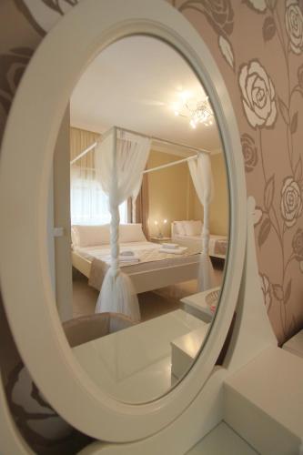 a mirror reflecting a bedroom with two beds at Alaçatı Çınar Boutique Hotel in Alaçatı