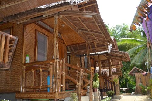 een houten huis met een veranda bij Jake and Zyra Place in San Vicente