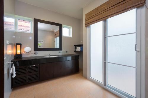 a bathroom with a sink and a mirror at Villa Bougainvillea in Hua Hin