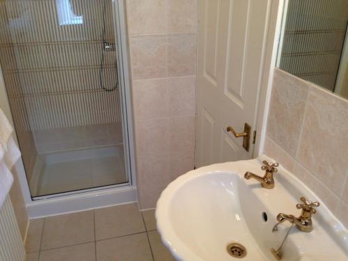 a bathroom with a sink and a shower at The Old Coach House in Blackpool