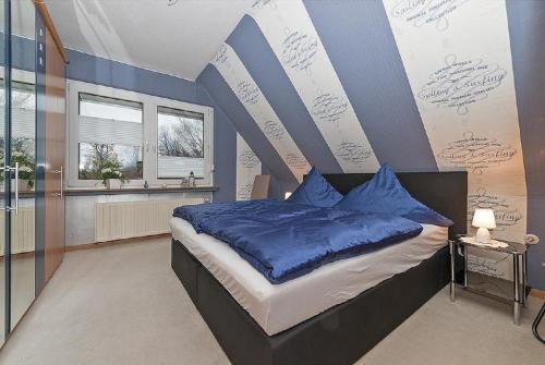 Ferienwohnung Poppe في Loxstedt: غرفة نوم بسرير كبير مع وسائد زرقاء