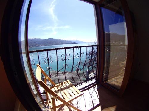 una silla en el balcón con vistas al agua en 'By the Lake' Apartments, en Ohrid