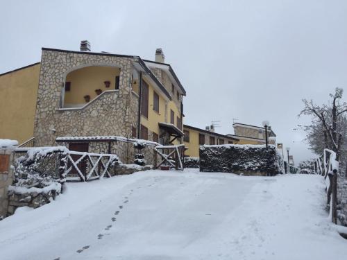 una strada innevata di fronte a un edificio di Appartamento i Cerri a Rocca di Cambio