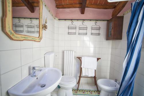 a white bathroom with a sink and a toilet at Fioralice in Fauglia