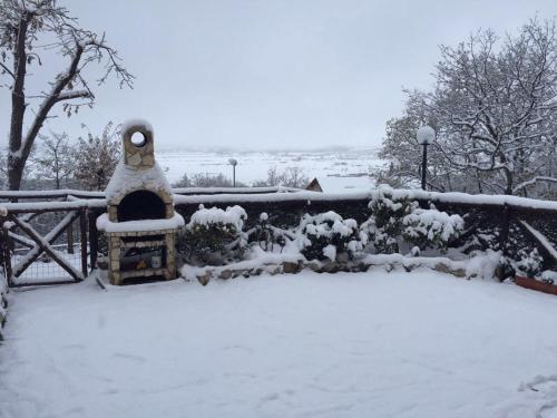 een tuin bedekt met sneeuw met een hek bij Appartamento i Cerri in Rocca di Cambio