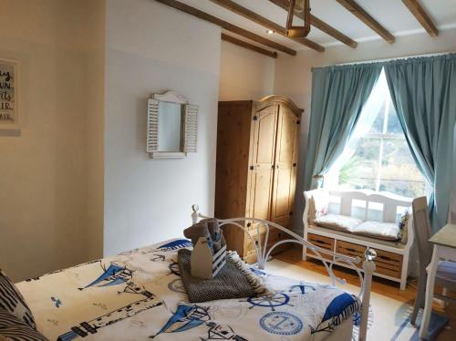 ein Schlafzimmer mit einem Bett und einem Fenster in der Unterkunft dog friendly nancecliff cottages in Looe