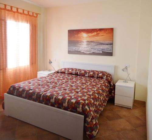 una camera con un letto e due comodini di Tramonto -Appartamenti OltreMare- Lido Conchiglie Gallipoli a Gallipoli
