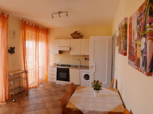 ガリポリにあるTramonto -Appartamenti OltreMare- Lido Conchiglie Gallipoliのテーブル付きのキッチン、テーブルと椅子付きのキッチン