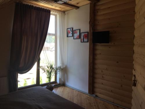 a bedroom with a bed and a large window at VIP House in Mykulychyn