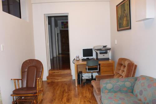 a living room with a couch and a desk with a computer at Mini Homestay in Auckland