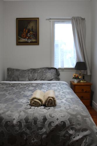 a bedroom with a bed with two towels on it at Mini Homestay in Auckland