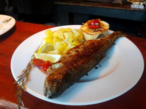 a plate of food with a piece of fish and potatoes at Guest House Kraljev Hrib in Kamniška Bistrica