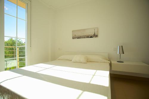 Un dormitorio blanco con una cama y una ventana. en Apartment Minimal, en Can Picafort