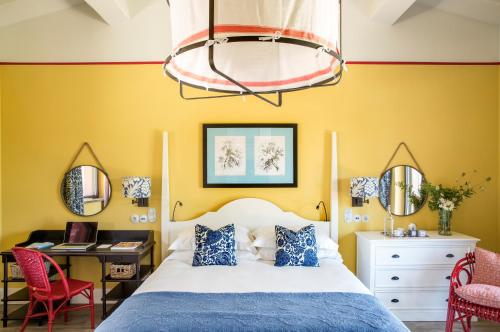 a bedroom with a bed and a desk and chairs at Locanda Rossa in Capalbio