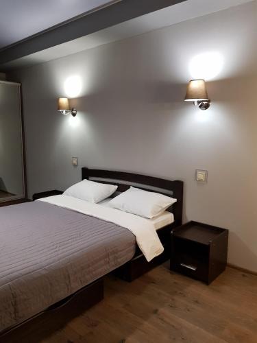 a bedroom with a bed and two lights on the wall at Prestige Apartments Kalnyshevskogo in Dnipro