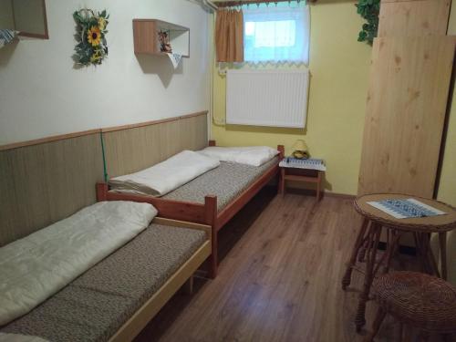 Habitación pequeña con 2 camas y mesa. en Ubytovanie v súkromí en Liptovský Ján