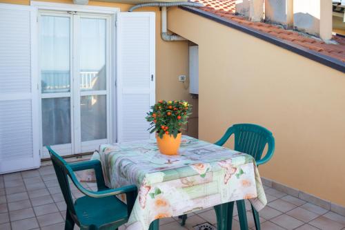 a table with a vase of flowers on a balcony at APPARTAMENTO "ARANCIO" SUL MARE in Cupra Marittima