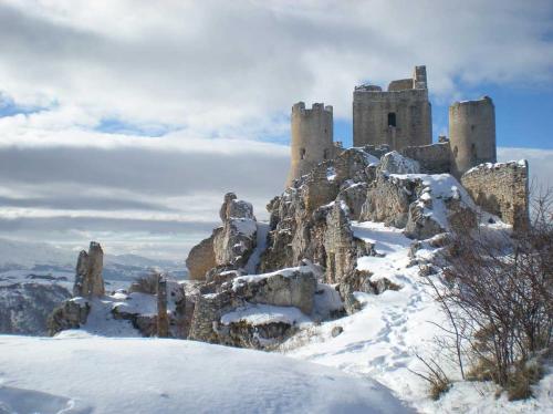 a castle on top of a mountain in the snow at Ammoglja in Calascio