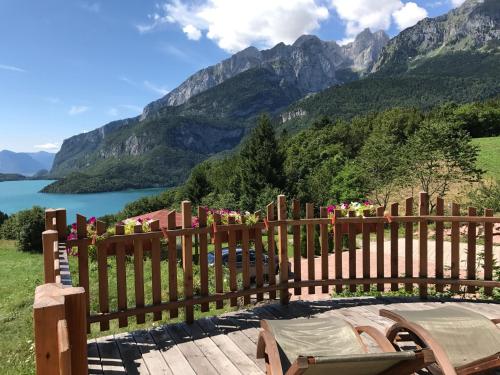a wooden fence with a view of a lake and mountains at Agriturismo Ai Castioni in Molveno