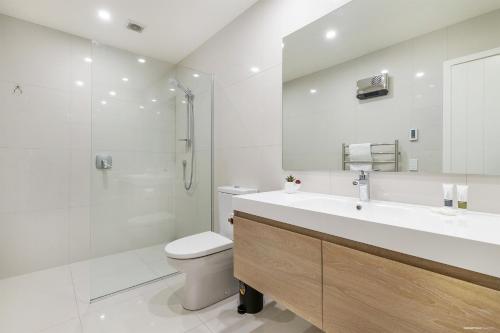 une salle de bains avec lavabo, toilettes et douche dans l'établissement Executive Living in Bluewater, à Queenstown
