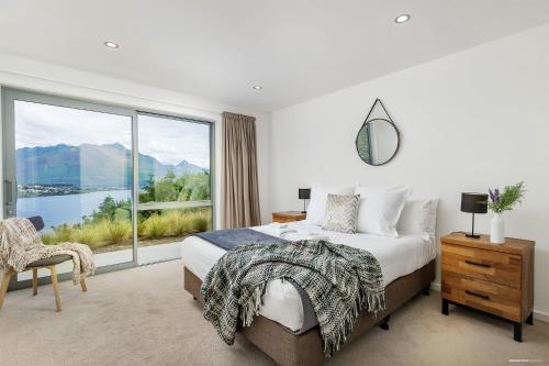 une chambre avec un lit et une grande fenêtre dans l'établissement Executive Living in Bluewater, à Queenstown