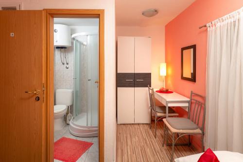 a bathroom with a toilet and a table in a room at Damira Rooms in Split