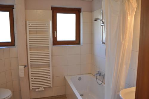 uma casa de banho com uma banheira, um WC e um lavatório. em Berghof em Berwang