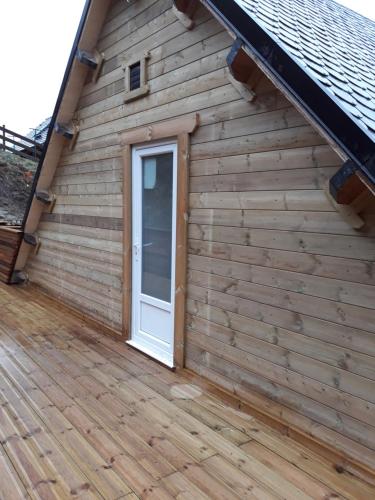 a door on the side of a wooden building at Les Roses Des Bois in Murat-le-Quaire