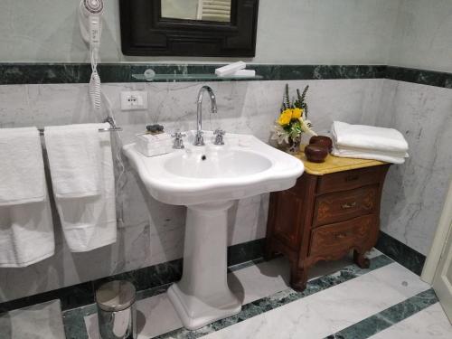 a bathroom with a white sink and a shower at B&B "La Bottega d'Arte" in Carrara