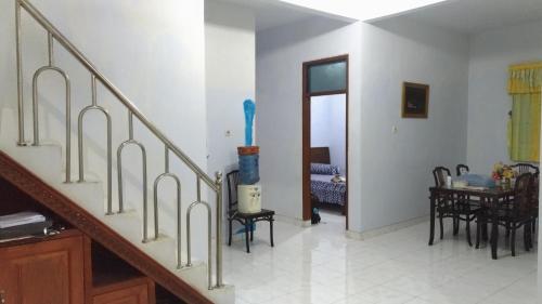 a living room with stairs and a dining room at Wisma Sayura Syariah in Cinangka
