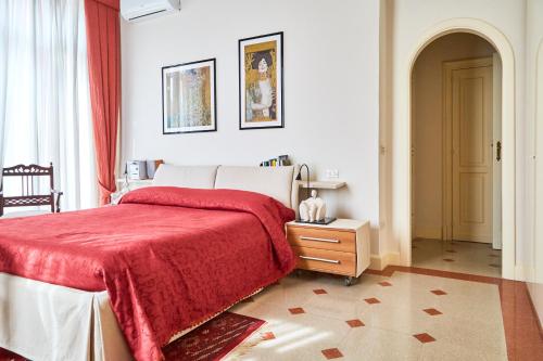 a bedroom with a bed with a red blanket at Suite Klimt P.zza Amedeo in Naples
