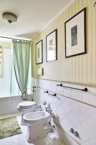 a white bathroom with a toilet and a sink at Suite Klimt P.zza Amedeo in Naples