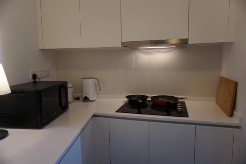 a kitchen with a stove and a microwave at THE HUB SS2 in Petaling Jaya