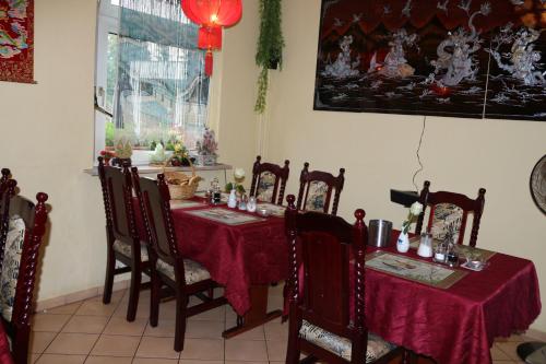 a dining room with a table and chairs with red table cloth at Hotel Alte Post in Bad Sooden-Allendorf