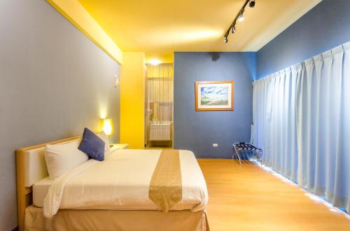 a bedroom with a king sized bed and blue walls at 光腳丫宜蘭民宿 in Dongshan