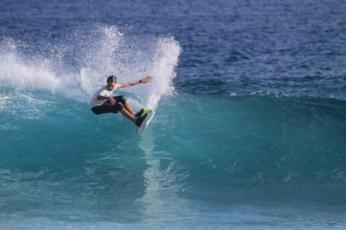 Un uomo che cavalca un'onda su una tavola da surf nell'oceano di Batuta Maldives Surf View a Thulusdhoo