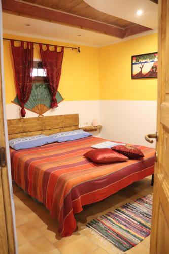 1 dormitorio con 1 cama con paredes de color naranja y amarillo en Appartamento Domu Mea 258 A en Santa Maria