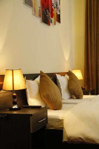a hotel room with a bed with pillows and a lamp at Tomu's Hotel in Gyumri