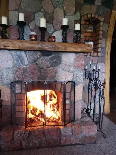 ein steinerner Kamin mit einem Feuer darin in der Unterkunft Relax House in Varkaliai
