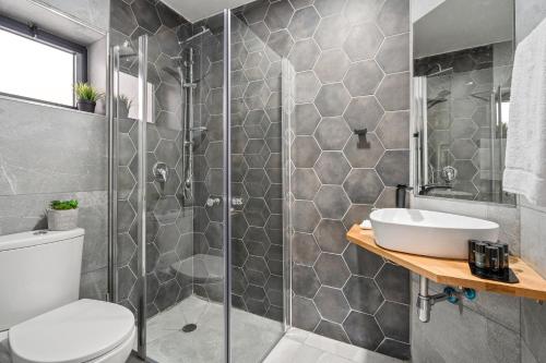 a bathroom with a shower and a toilet and a sink at Hotel La Finca - Luxury Suites Hotel in Beer Sheva