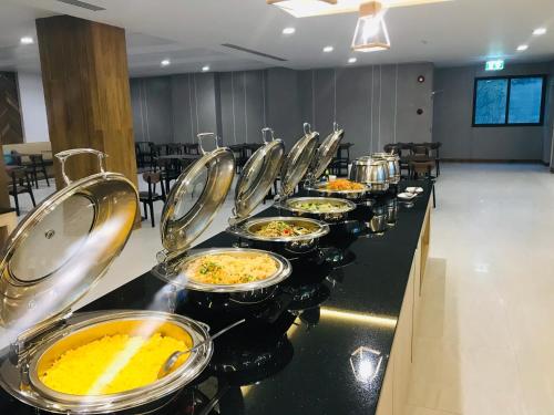 une rangée de tables de buffet alignées avec de la nourriture dans l'établissement Paragon Grand Resort, à Jomtien Beach
