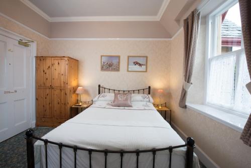 1 dormitorio con 1 cama, 2 lámparas y ventana en Dall Lodge Country House, en Killin