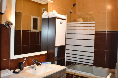 a bathroom with a sink and a shower and a mirror at BéziersApart *** vivre à la française comme un habitant in Béziers