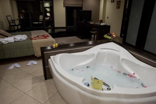 a bath tub in a room with a living room at Manhattan Village Hotel in Sulmona