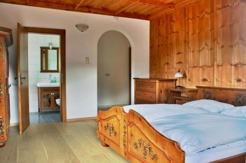 アルプバッハにあるJuwel Apartment in Landhaus Christina Alpbachの木製の壁のベッドルーム1室(大型ベッド1台付)