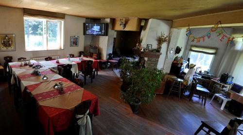 comedor con mesas y sillas y TV en Strandzhata's House en Pasarel