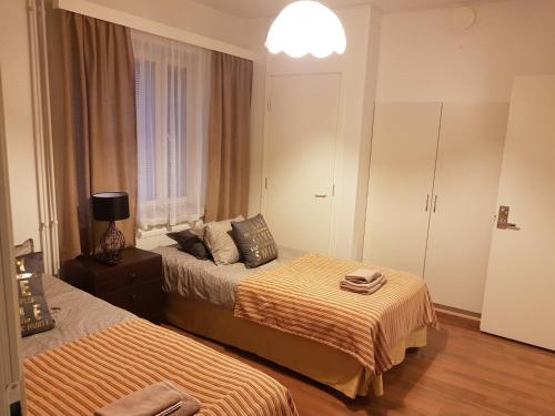 a hotel room with two beds and a lamp at Gasthaus Patruuna in Joutseno