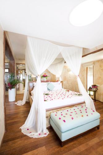 a bedroom with two beds with white drapes at Tulia Zanzibar Unique Beach Resort in Kiwengwa