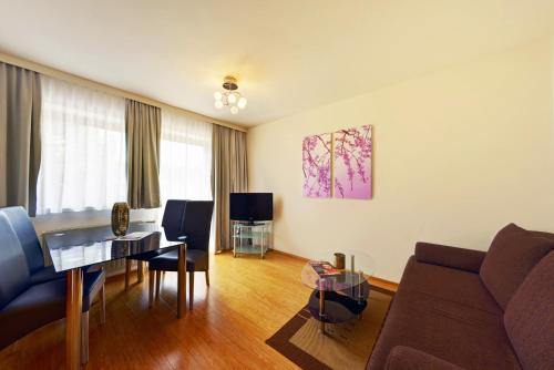 a living room with a couch and a table at Feriendorf Rosental by S4Y - Selbstversorger Appartements in Feistritz im Rosental